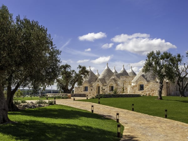 Manicured lawns and stone-flagged paths link the two houses. 